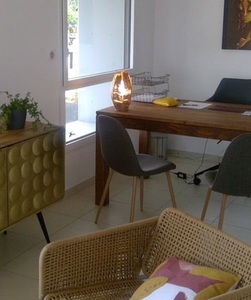 Bureau moderne et design pour un espace de travail inspirant Bureau moderne et lumineux. Grand bureau en bois, chaises grises, lampe design, meuble doré texturé, fauteuil en osier. Espace accueillant.